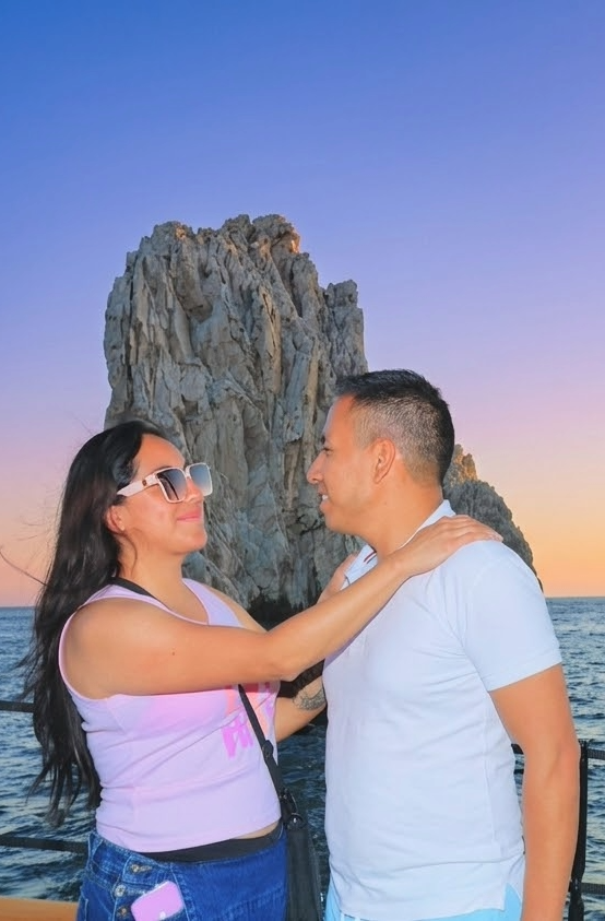 Jazmín y Jesús frente a una formación rocosa junto al mar